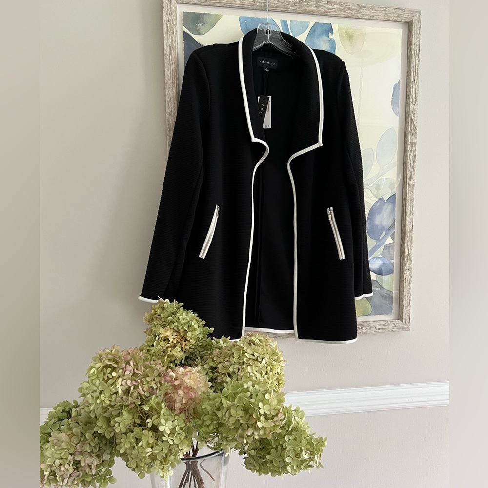 Premise coat in black with white trim & zipper pockets. Size small